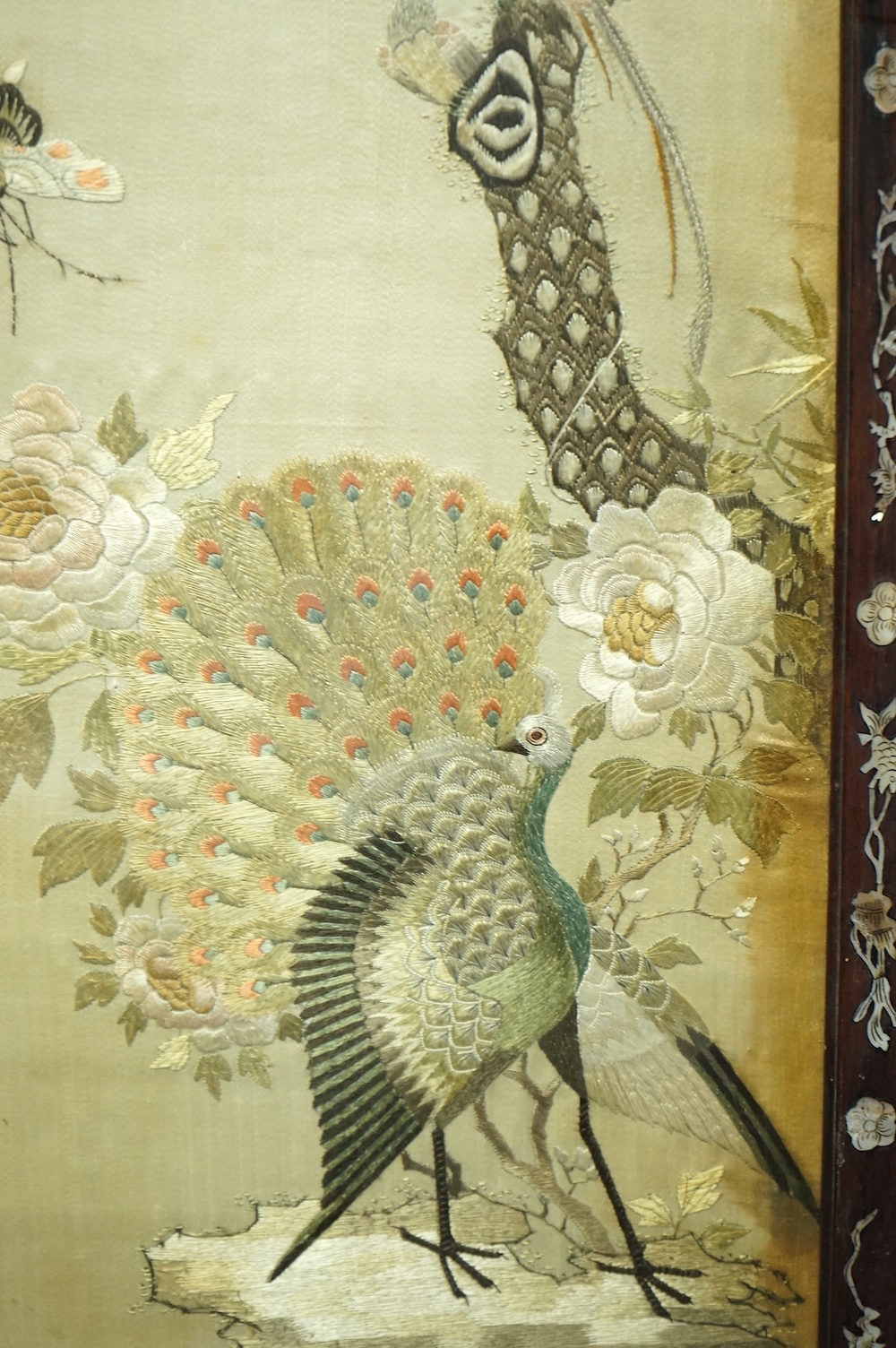 A pair of Chinese embroidered ‘Hundred Bird’ silkwork pictures, c. 1900, in Hongmu and mother-of-pearl inlaid frames, total size 99cm x 32cm. Condition - dark staining and tears to the silk, losses to the mother of pearl
